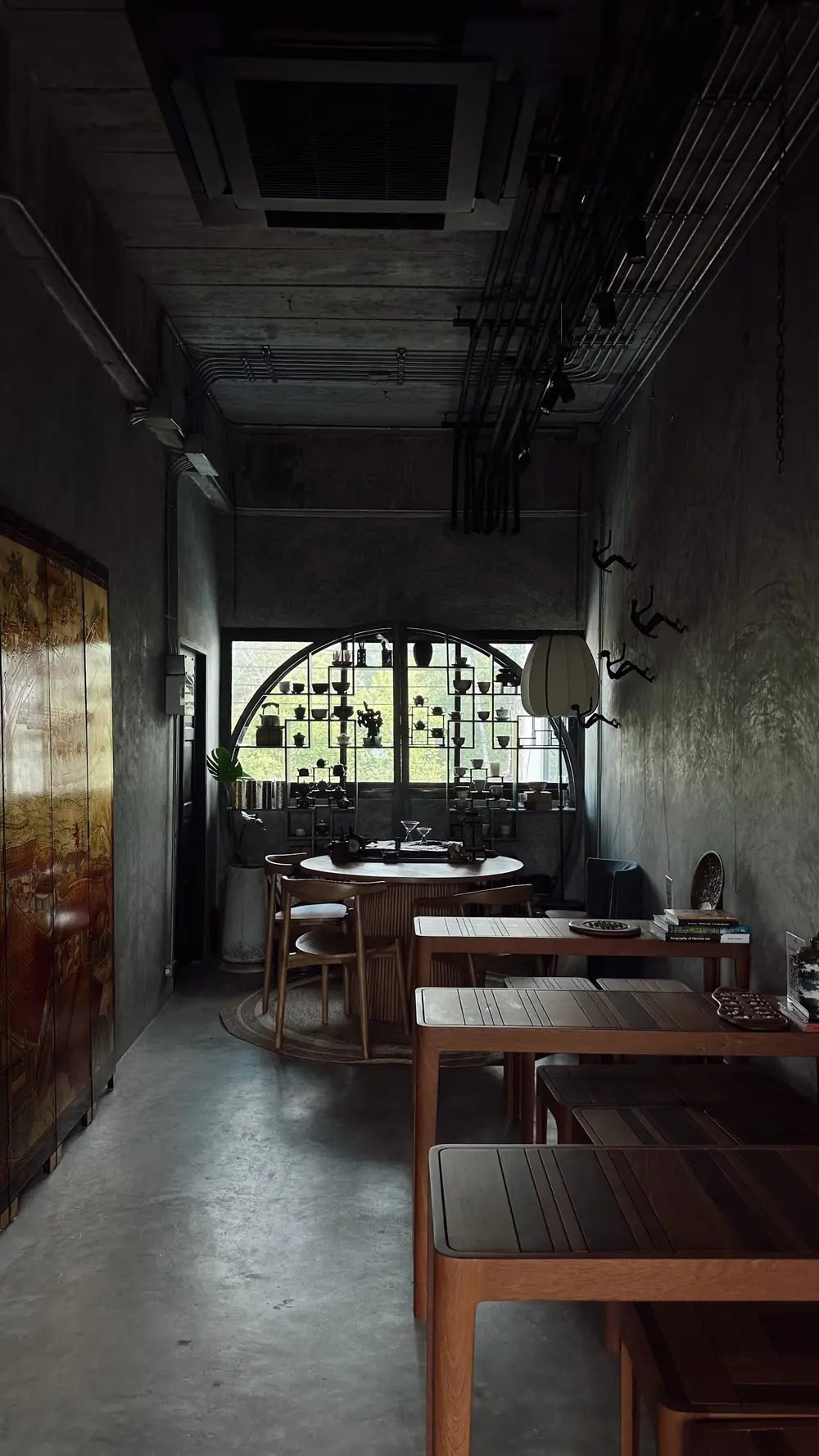 Long room with concrete walls and wooden tables
