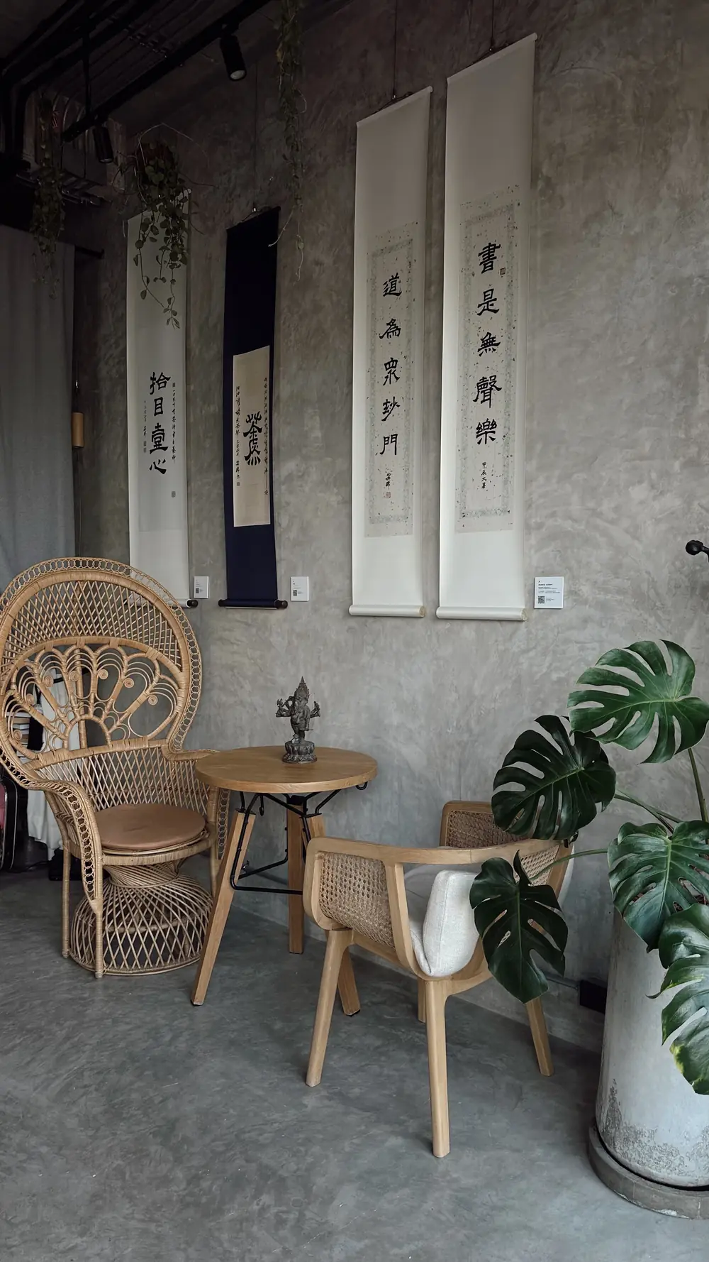 Rattan peacock chair and calligraphy scrolls in the tea house
